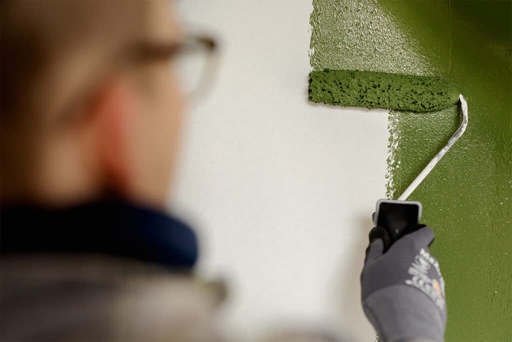 Forrest green maling på væg med malerrulle