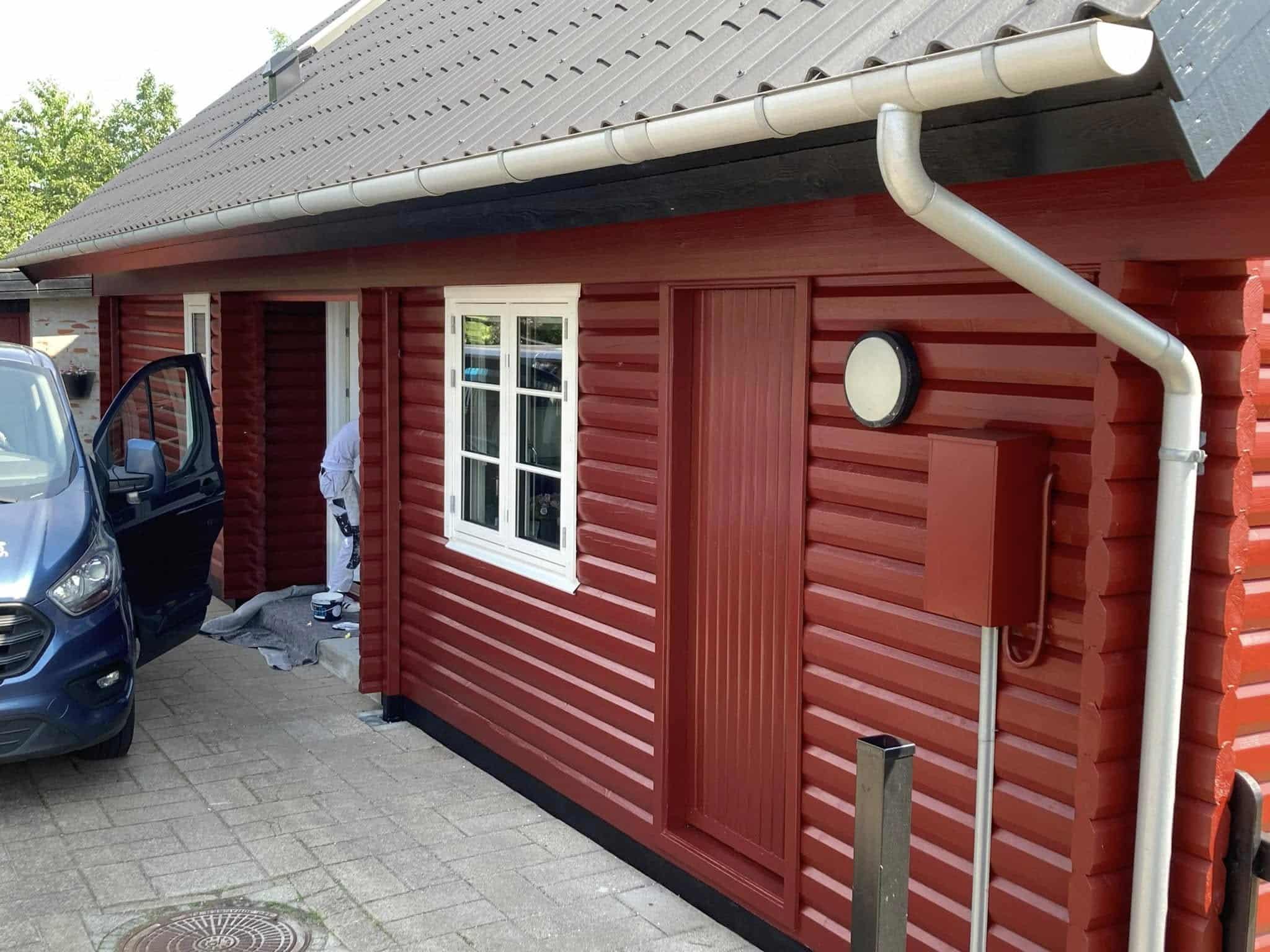 Rødt sommerhus nymalet med indkørsel